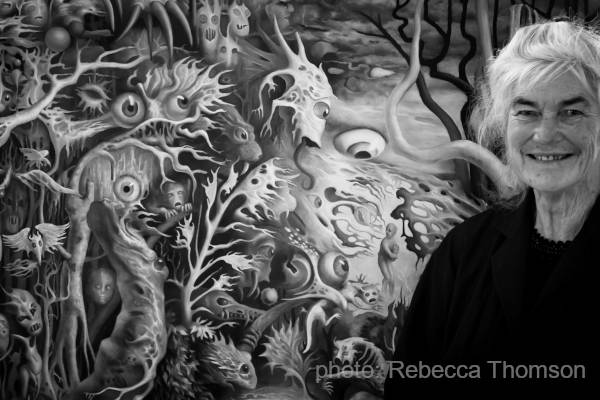 black and white photograph of the artist in front of one of her paintings