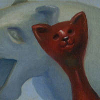 sleek brown plastic cat with ghostly badly carved wooden lion in background
